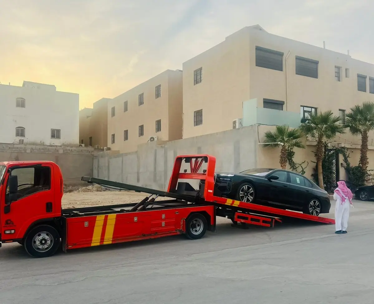 سطحة هيدروليك حمراء تنقل سيارة BMW فاخرة في الدمام
